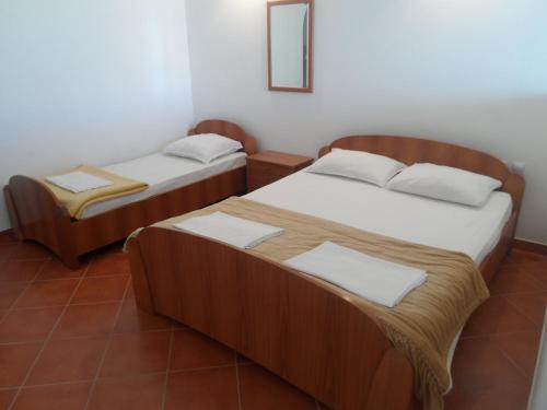2 letti in una camera con specchio di Apartments Kepi Gjerana a Ulcinj