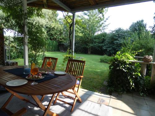 einen Holztisch und Stühle auf einer Terrasse in der Unterkunft Gartenwohnung JULIANA Gstadt LÄUFERs CHIEMSEE HOLIDAY HOME in Gstadt am Chiemsee