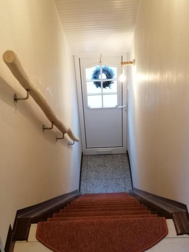 a set of stairs with a door and a red rug at Haus Lupo am Kanal in Castrop-Rauxel