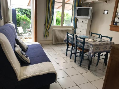 un salon avec un canapé et une table avec des chaises dans l'établissement Maison de vacances Arzaël à 200m de la plage célèbre de Mr Hulot, à Saint-Nazaire