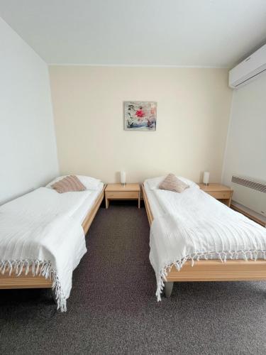 a room with two beds and two tables at Pension Ingrid in Neutal
