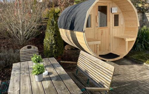 eine kleine Holzhütte mit einem Tisch und einer Bank in der Unterkunft Traumhaus am Maar in Schalkenmehren