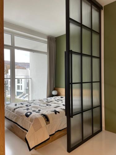a bedroom with a bed and a large window at Turbo Apartament pod Szyndzielnią i Dębowcem in Bielsko-Biala