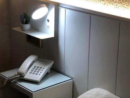 un teléfono blanco sentado sobre una mesa en Hotel Claramar, en Platja d'Aro