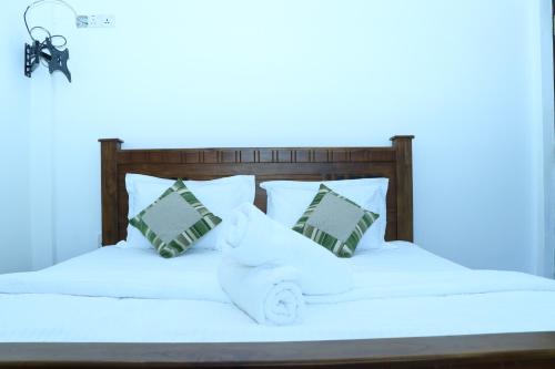 a white bed with white sheets and pillows at White House Bungalow Hatton in Hatton