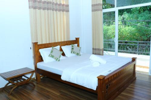 a bedroom with a bed and a large window at White House Bungalow Hatton in Hatton