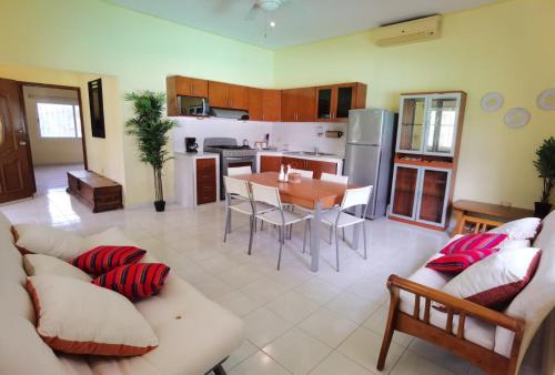 Paradise Ranch في كوزوميل: غرفة معيشة كبيرة مع طاولة ومطبخ