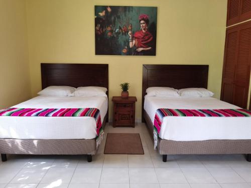 due letti uno accanto all'altro in una stanza di Paradise Ranch a Cozumel