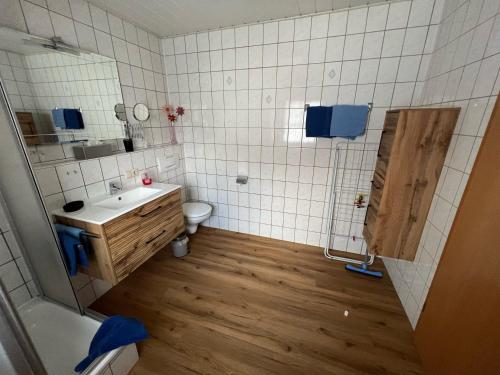 a bathroom with a sink and a toilet and a mirror at Ferienwohnungen Kral in Grainau