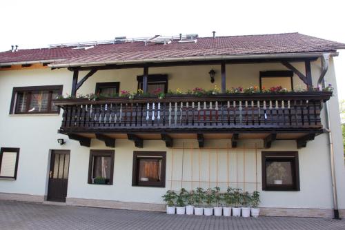 a building with a balcony with flowers on it at Ferienwohnung Bayer in Kurort Gohrisch