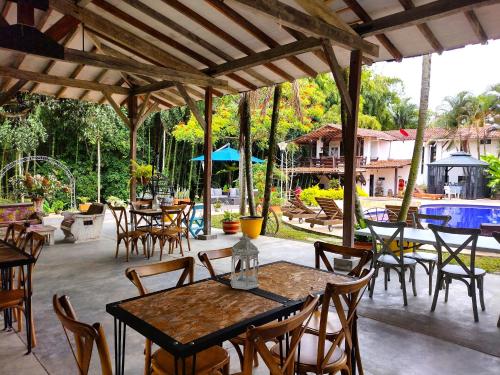 an outdoor patio with tables and chairs and a pool at Villa Juana Hotel in Pereira