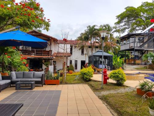 a patio with couches and umbrellas in front of a building at Villa Juana Hotel in Pereira