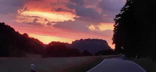 a sunset over a road with the sun setting at Ferienwohnung Bayer in Kurort Gohrisch