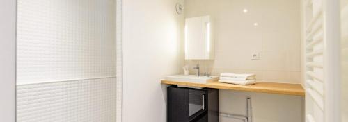 La salle de bains blanche est pourvue d'un lavabo et d'un miroir. dans l'établissement 302 - Appartement Duplex Moderne - Jeanne d'Arc, Toulouse, à Toulouse