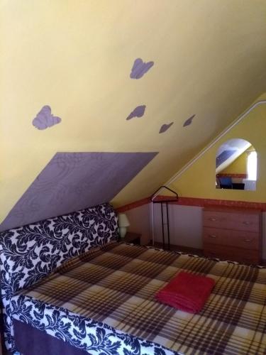 a bedroom with a bed in a attic at Gesztenyes Vendeghaz in Bükkszék