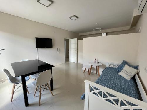 um quarto com uma cama, uma secretária e um piano em Dpto Moderno - 1 dormitorio, hasta 4 personas em Tandil
