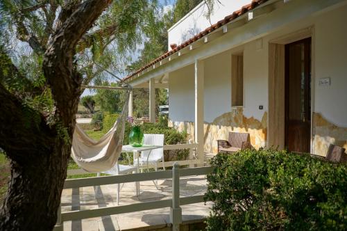 a porch with a hammock and a house at Agriturismo Tenuta Carrino in Porto Cesareo