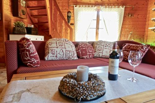 a living room with a couch and a bottle of wine at Ferienhaus Bergglück in Nonnweiler
