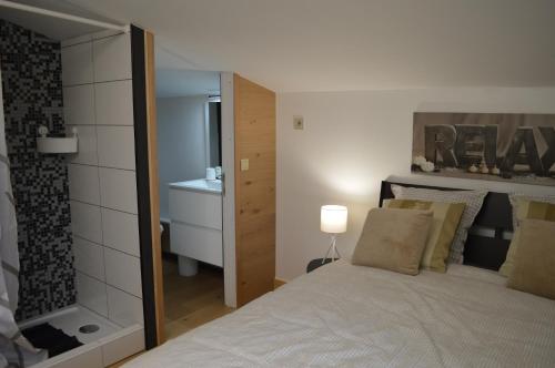 a bedroom with a large bed and a bathroom at La Lunadeléo in Wépion