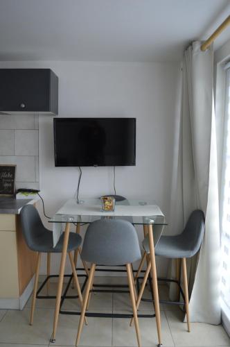 a desk with two chairs and a computer monitor at La Lunadeléo in Wépion
