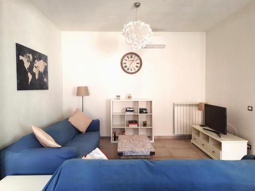 a living room with a blue couch and a clock at Casa di Nicola in Viareggio
