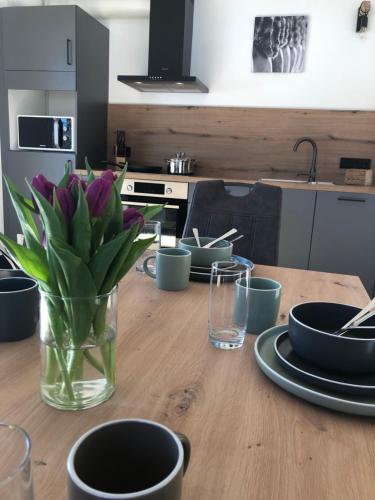a wooden table with a vase of purple flowers on it at Ferienwohnung Familie Zint in Sonthofen