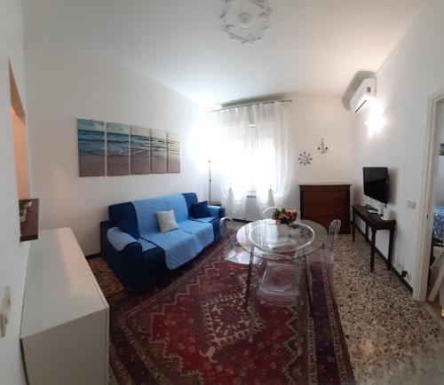 salon z niebieską kanapą i szklanym stołem w obiekcie La Nena Appartamenti w mieście La Spezia