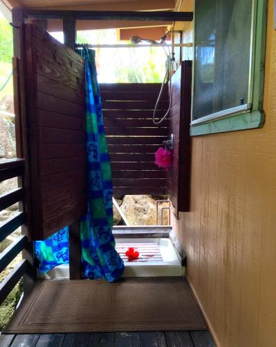 a door to a shower with a curtain on it at Kalani Hawaii Private Lodging in Pupukea