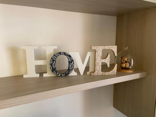 a shelf with a sign that says the word love at AGM Suite Rome Airport FCO - Attico Parco Leonardo in Fiumicino