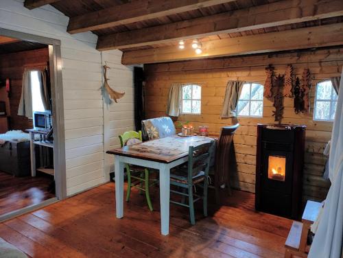 Zimmer mit einem Tisch und einem Kamin in einer Hütte in der Unterkunft Het Swadde huisje in Twijzelerheide