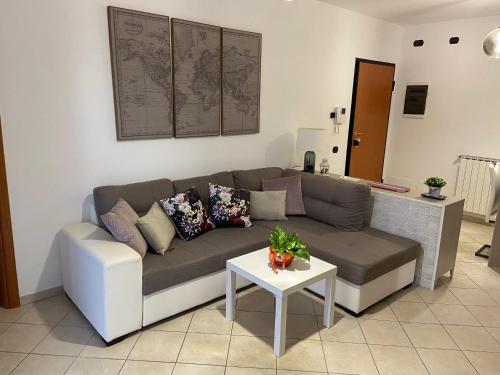 un soggiorno con divano e tavolo di AGM Suite Rome Airport FCO - Attico Parco Leonardo a Fiumicino