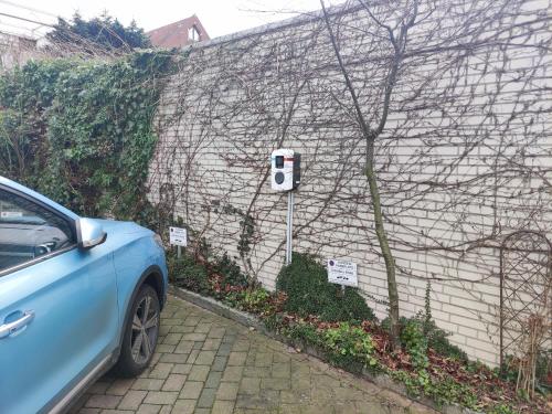 a blue car parked in front of a brick wall at Schäfers Hotel, Self-Check-in, Cafe und Bäcker am Hotel in Vechta