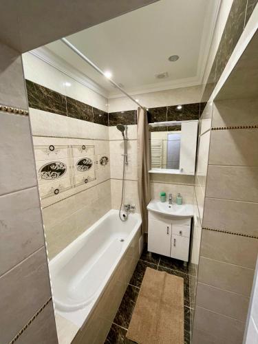 a bathroom with a tub and a sink at В САМОМУ ЦЕНТРІ МІСТА, ЗДАЮТЬСЯ В ПОДОБОВУ ОРЕНДУ, АПАРТАМЕНТИ ZONEofCOMFORT in Chernivtsi