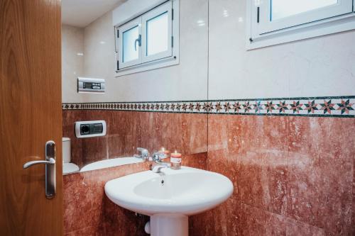 a bathroom with a sink and a window at EL SEXTO DE LA PLAYA + PARKING GRATIS in Gijón