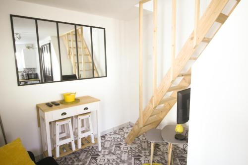 Cette chambre dispose d'un escalier, d'une table et d'un miroir. dans l'établissement Maisonnette, à Flins-sur-Seine