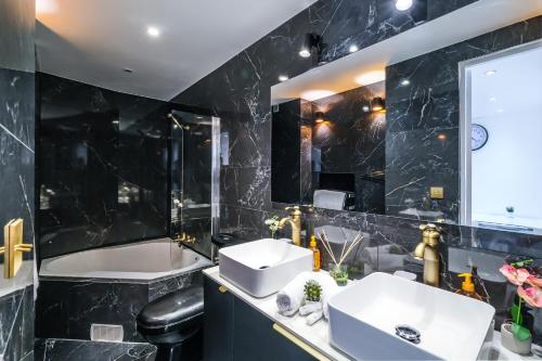 La salle de bains noire est pourvue de 2 lavabos et d'une baignoire. dans l'établissement Magnifique appart 3 pièces Cannes Croisette ideal 4 personnes, à Cannes