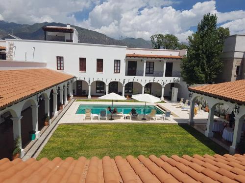 a large white building with a pool and lawn chairs at Iraola Hotel Boutique in Cafayate