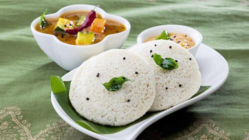 a plate of food with two tortillas and a bowl of soup at Hotel Castle Manor - Auroville Beach in Pondicherry