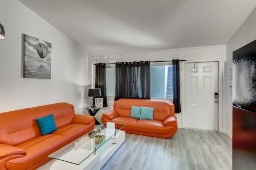 a living room with two orange couches and a table at Coral Sands 1br/1ba Close 2 Beach! in West Palm Beach