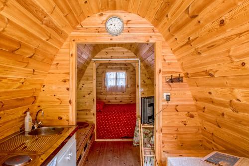 una cocina en una cabaña de madera con un reloj en la pared en Domaine du Clégrio, en Guéhenno