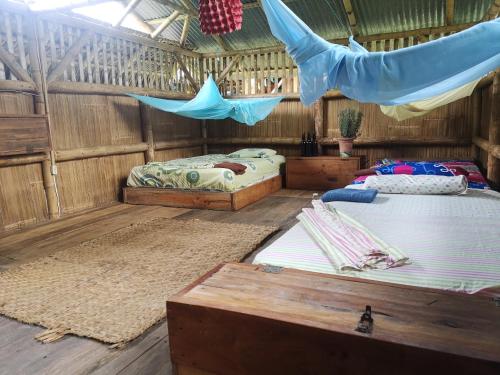 a bedroom with two beds and a hammock in it at Maracumbo Lodge in Mompiche
