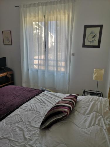 une chambre avec un lit blanc avec une fenêtre dans l'établissement T3 vue mer à Propriano, à Propriano