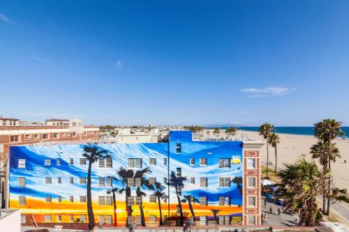 a blue building with palm trees and the beach at Venice Suites in Los Angeles