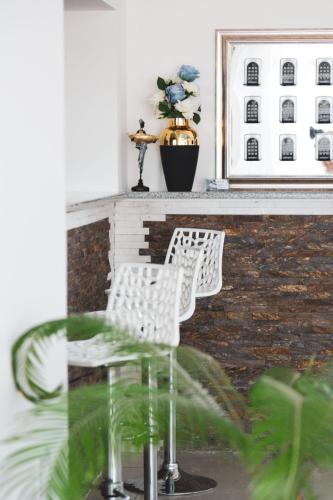 two white chairs sitting in front of a table at ForS Konak Apartments in Belgrade