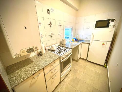 eine kleine Küche mit einem Herd und einem Kühlschrank in der Unterkunft Departamento Güemes in San Salvador de Jujuy