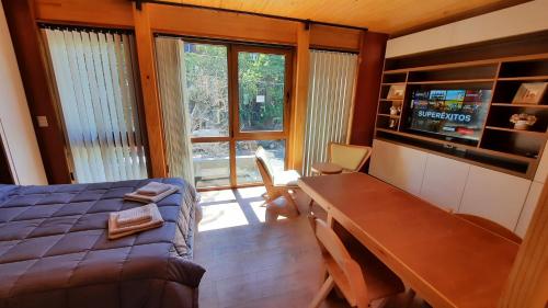 1 dormitorio con cama, escritorio y ventana en Hermoso monoambiente en el centro de SMA, muy cálido y modernoso V407 en San Martín de los Andes
