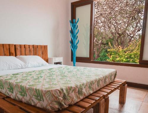 a bedroom with a large bed with a window at The Eco Palace Hostel in Búzios
