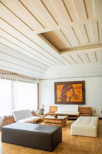 a living room with a coffered ceiling and a couch at The Eco Palace Hostel in Búzios