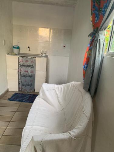 a white bed in a room with a kitchen at Pousadinha da Lulu - Pontal Mangue Seco in Indiaroba