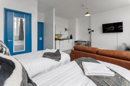 - un salon avec deux lits et un canapé dans l'établissement City Centre Studio 7 with Kitchenette, Free Wifi and Smart TV by Yoko Property, à Middlesbrough